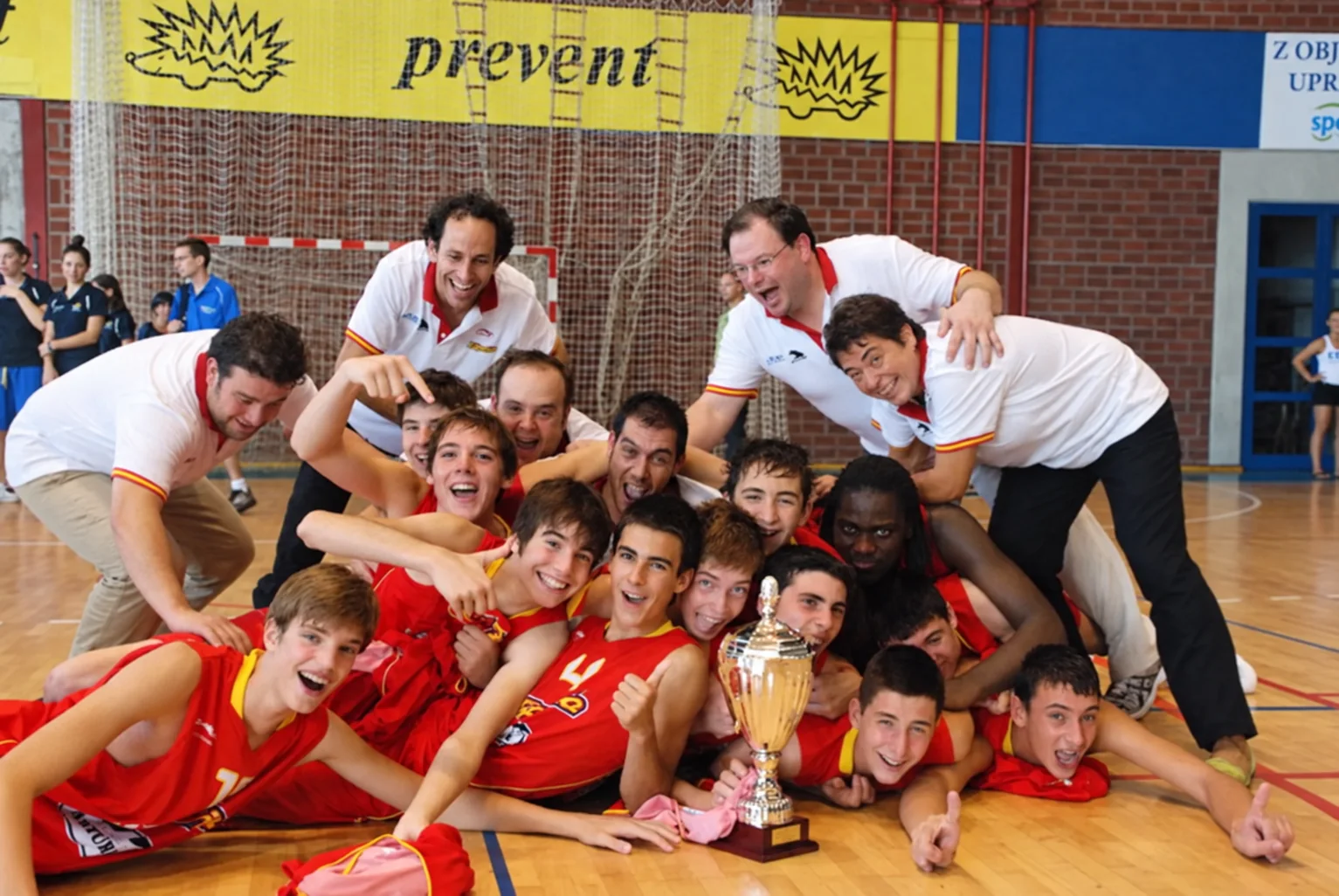Equipo de baloncesto celebrando junto a un trofeo